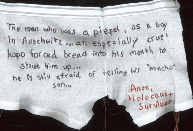 a pair of young boys white boxer brief underwear is embroidered with an excerpt of a Holocaust survivors story in slate grey thread